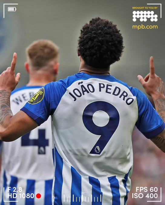 A photo taken from behind Joao showing the name and number on the back of his shirt while he points to the sky. What a player!