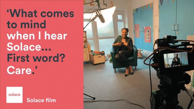 Image Description: Woman smiling in a chair on film. Caption reads ' What comes to mind when I hear Solace... First word? Care'