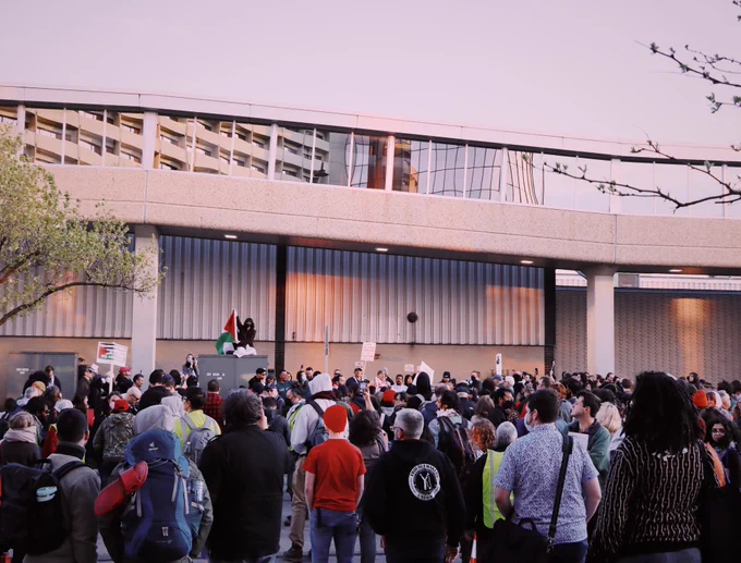a large crowd of labor notes attendees spilling over into the street at a pro palestine protest put on by labor for palestine.