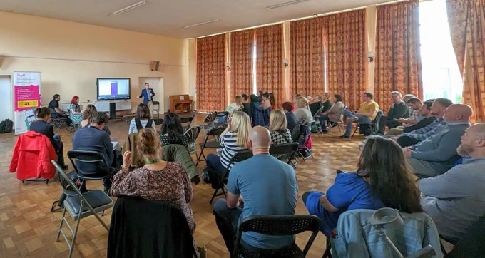 Innovate Trust CEO Nick French standing in front of a screen, presenting to a room of people