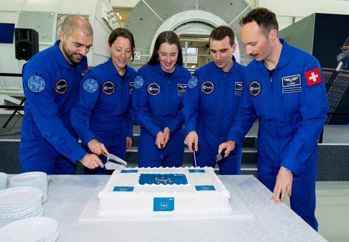 Photo of ESA astronauts Pablo Álvarez Fernández, Sophie Adenot, Rosemary Coogan, Raphaël Liégeois and Marco Sieber cutting a cake, celebrating their graduation at ESA's European Astronaut Centre in Cologne, Germany.