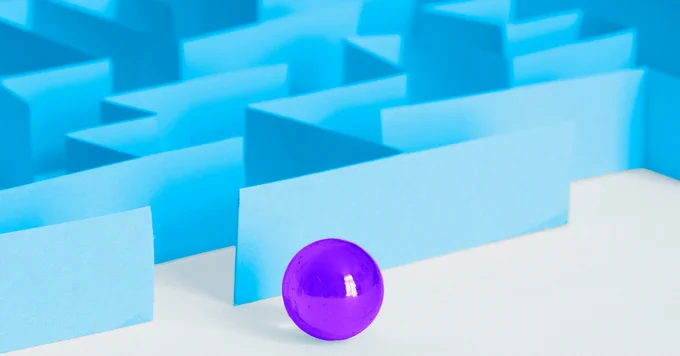 Shiny purple ball sitting in front of a blue maze
