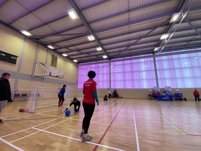 Mid game photo from the right side of the court. The ball has just been dropped in to re-start the game. The rest of the image shows the officials table in the background.