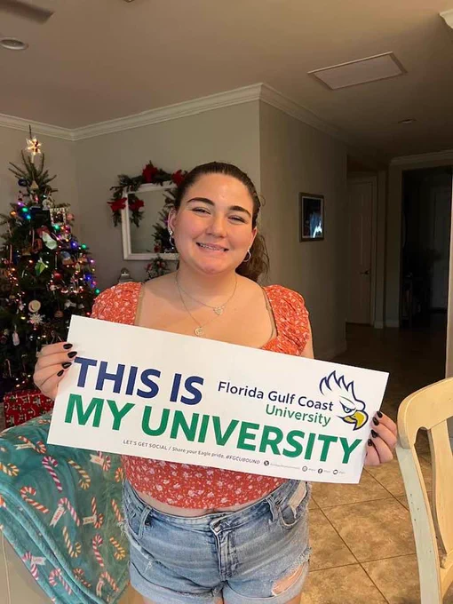 a student holds up a banner that reads  THIS IS MY UNIVERSITY