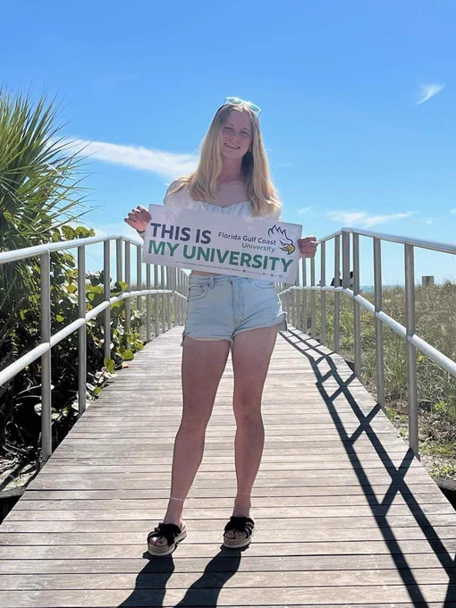 a student holds up a banner that reads  THIS IS MY UNIVERSITY