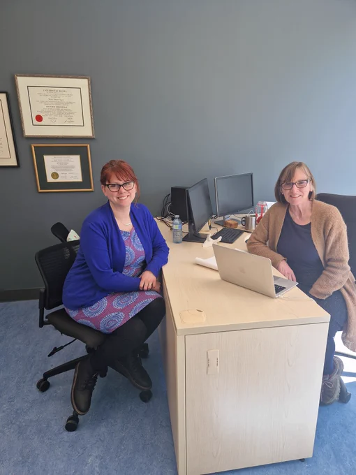 Tai and Mary sitting opposite each other in Mary's office