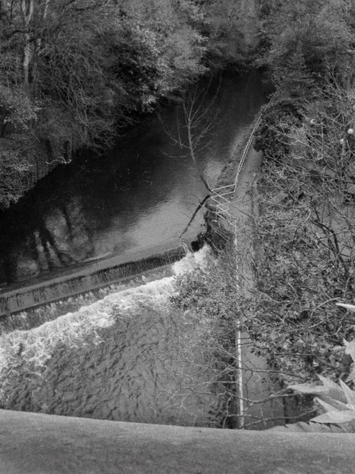 Black and white photograph of the Water of Leith from an overhead bridge