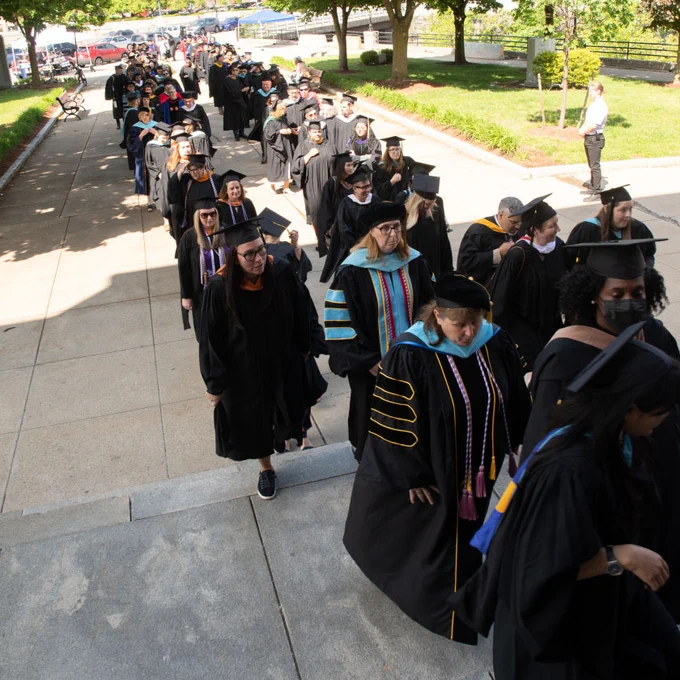 people in caps and gown line up outside