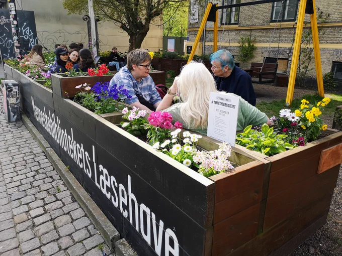 Readers and books sitting in the Human Librarys Reading Garden in Copenhagen for the opening of Season 4 on Sunday the 28th of April, 2024.