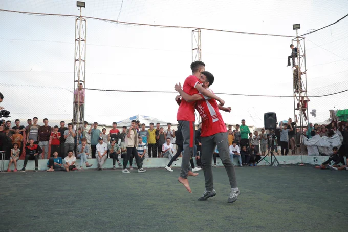 Two young people hug one another 
