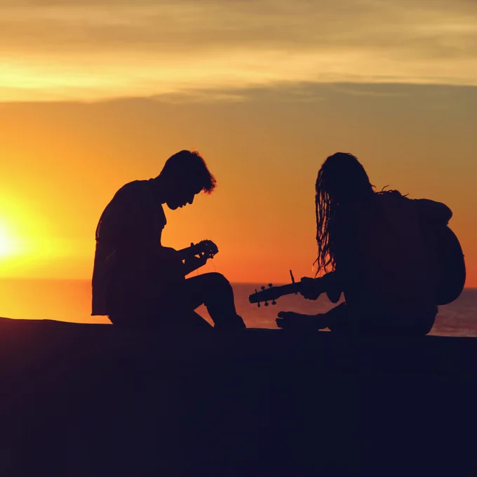 silhouette of man and woman playing guitars