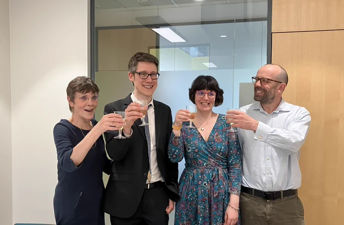 Tim and his three supervisors toasting his success with champagne