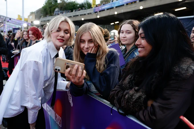 Three people taking a photo at a red carpet premiere