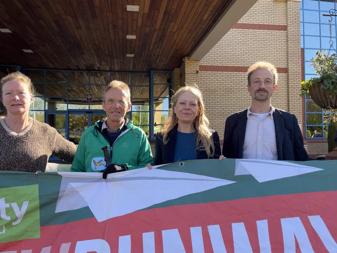 Cllrs Lisa Scott, Paul Chandler, Jonathan Essex and Sian Berry with a Green Party banner saying ‘No new runways’ outside the hotel hosting the Gatwick expansion examination hearing,