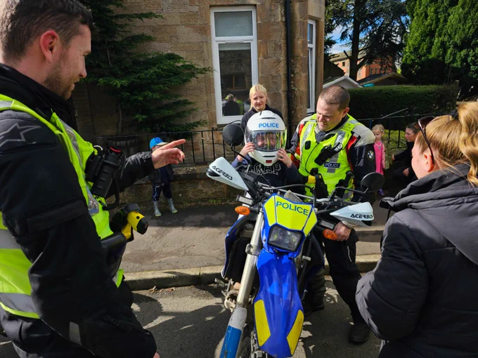 police officers with young child sitting on police motorbike
