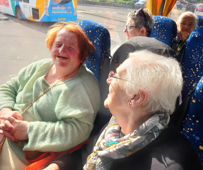 Janet and Angela sat on a bus in laughter and conversation