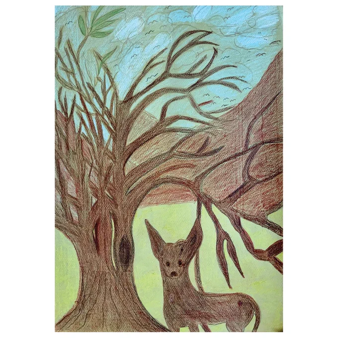 Image shows a deer standing next to a tree in front of a mountain.