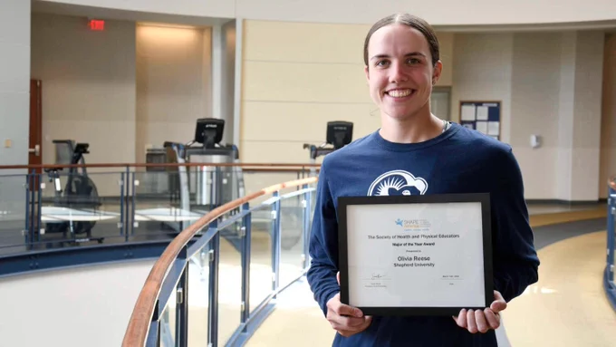Olivia Reese standing in the Wellness Center rotunda with her SHAPE-America award.