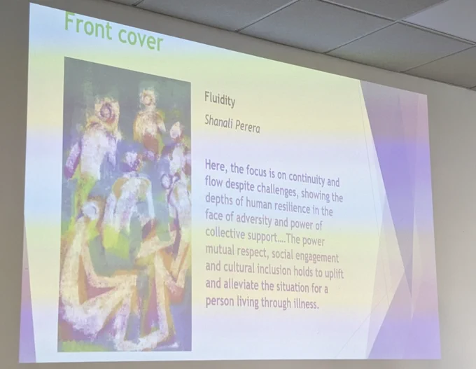 A slide showing the original artwork by Shanali Perera which is featured on the front cover of the Oxford Handbook of CAT. One figure is surrounded by six other figures in hues of blue green purple and brown. Text beside it reads: Fluidity - Shanali Perera - "Here, the focus is on continuity and flow despite challenges, showing the depths of human resilience in the face of adversity and the power of collective support... The power mutual respect, social engagement and  cultural inclusion holds to uplift and alleviate the situation for a person living through illness " 