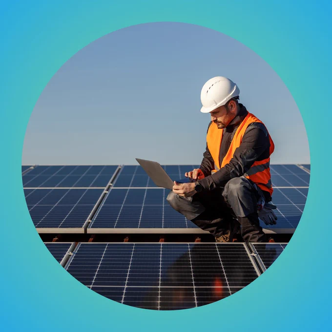 Man on roof with solar panels. Credit: AdobeStock