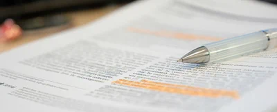 Close up image of some text on a journal page with a pen resting on the page.