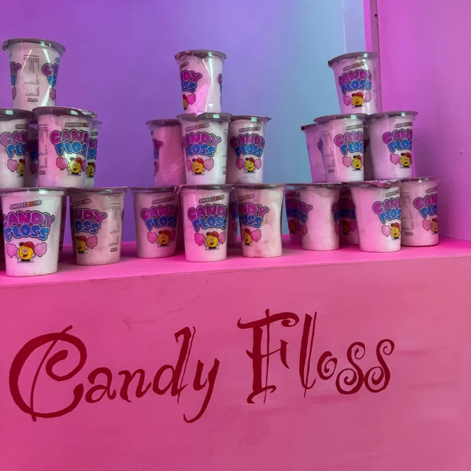 Candy floss tubs sit stacked up ready for audience members to grab. 