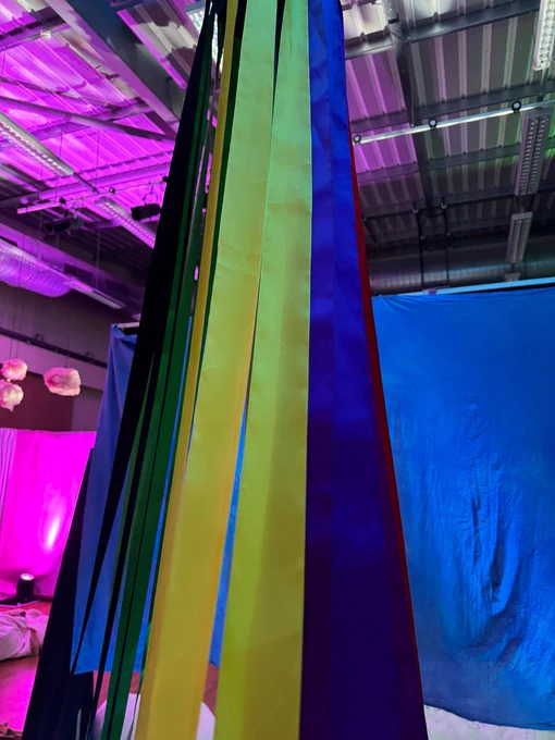 A maypole stands proud in the Seeing zone. Bright coloured ribbons hang off it. 
