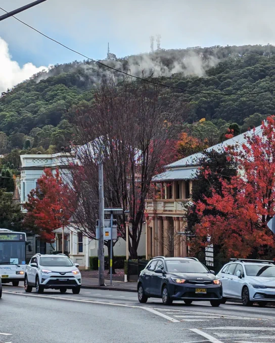 A street scene in Bowral, NSW, Australia, with Mount Gibraltar in the background, partially shrouded in mist