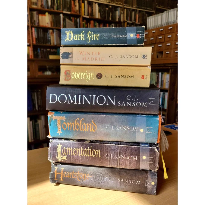 Image shows a pile of 7 books written  by C.J. Sansom
