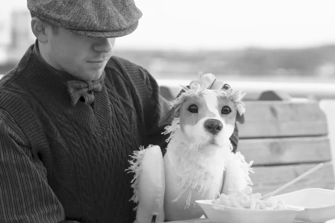 A photo showing a man holding a puppet dog 