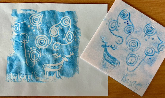 Photo of rock art print and printing board depicting cup and ring marks and a stag in blue paint.