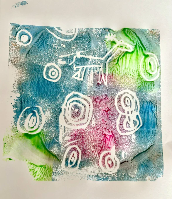 A photo of a multicoloured print with cup and ring marks and a stag.