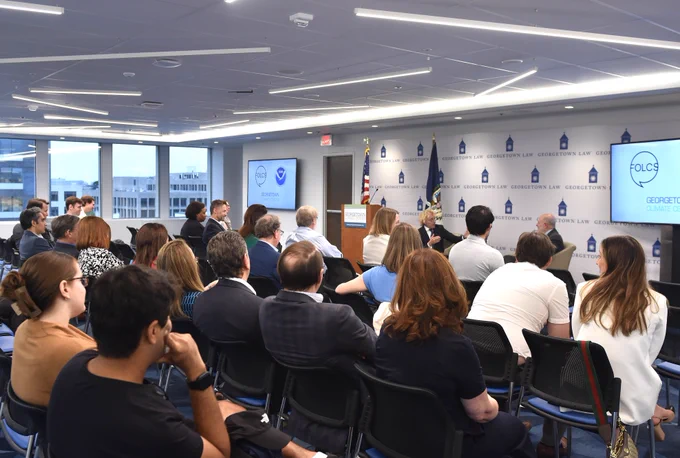 A full audience listens to the conversation between Thane Rosenbaum and Dr. Richard Spinrad in a bright event space.