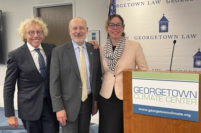 Thane Rosenbaum, Dr. Richard Spinrad, and GCC's Kate Zyla smile for a picture next to a lectern bearing Georgetown Climate Center's logo.