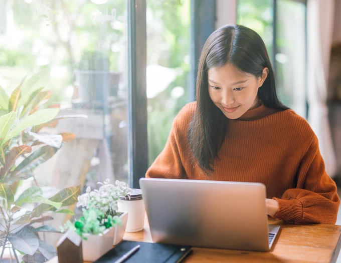 Young person sitting in front of an open laptop.