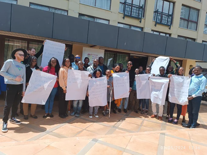 A group of people holding paper banners with messages on them. 