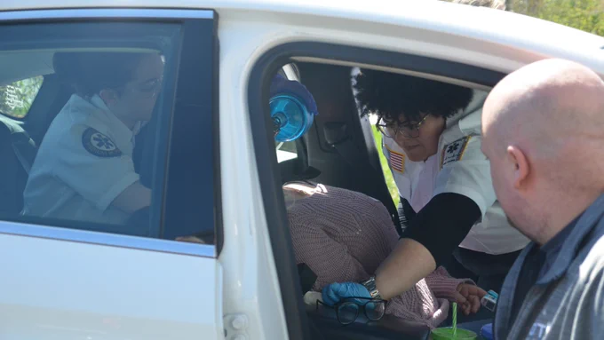 Spring Lake Park High School students respond to a volunteer playing a victim in a car during an Opportunities in Emergency Care drill. 