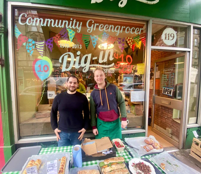 Two people smiling outside Dig In community greengrocer