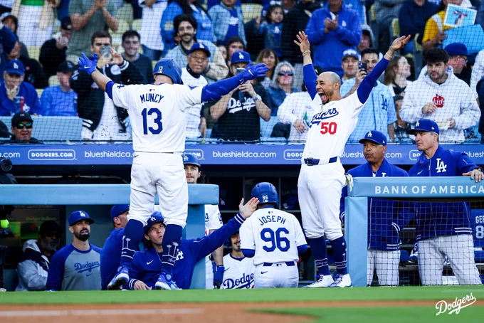 Mookie Betts celebrates outside the dugout with Max Muncy after hitting a home run.