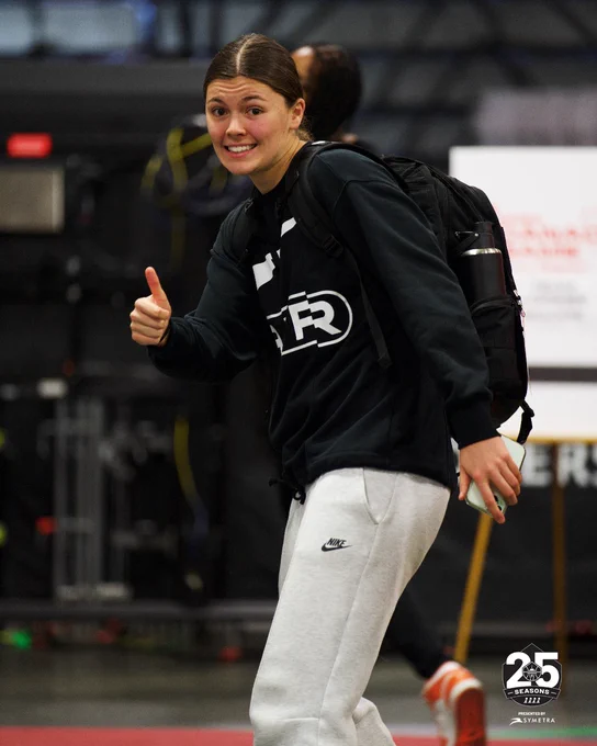 Jade Melbourne giving the camera a thumbs up while walking through the loading dock and Rogers Place