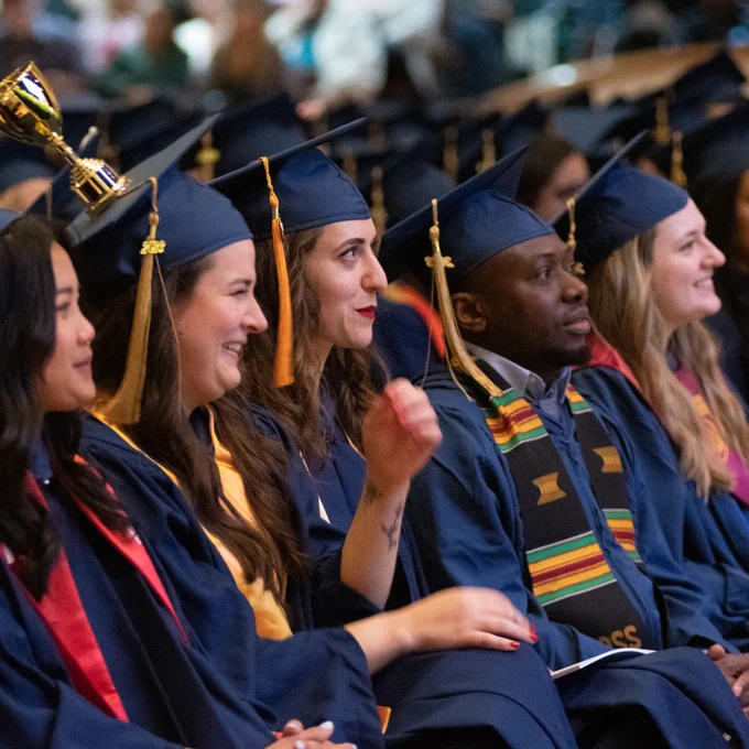 people in caps and gowns sit in audience