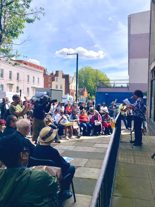 Dr Margaret Busby addresses the crowd outside the premises of Hackney CVS HQ, which James Baldwin visited in 1985!