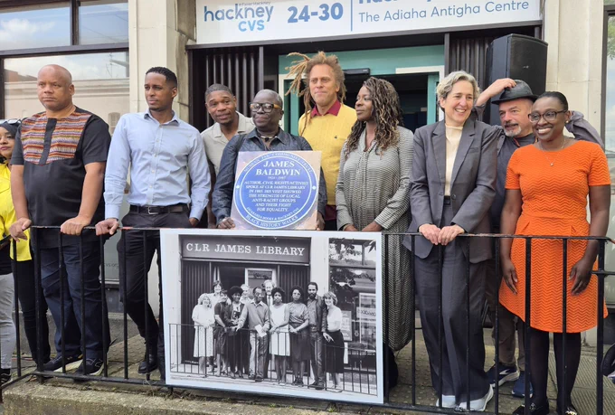 A group photo with a picture of James Baldwin’s visit in 1985 plus a copy of the blue plaque