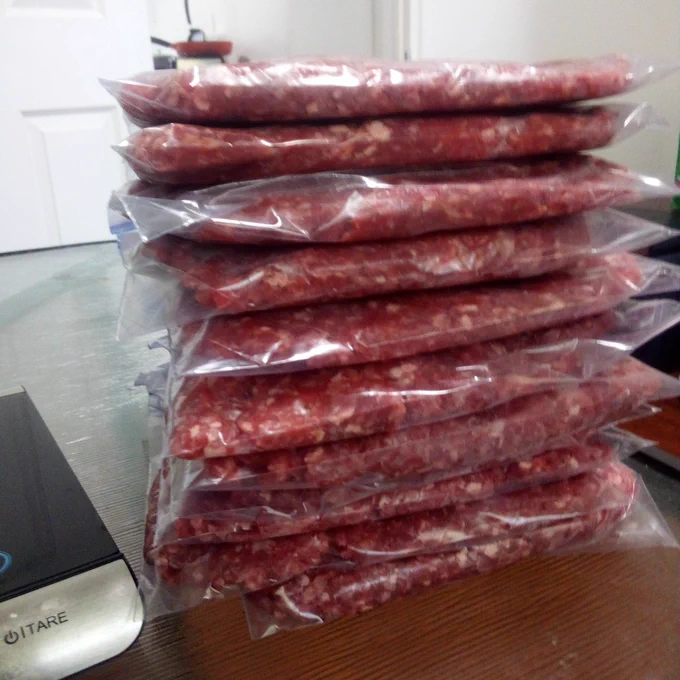 A stack of ziplock freezer bags containing 10 to 12 ounces of ground beef each.