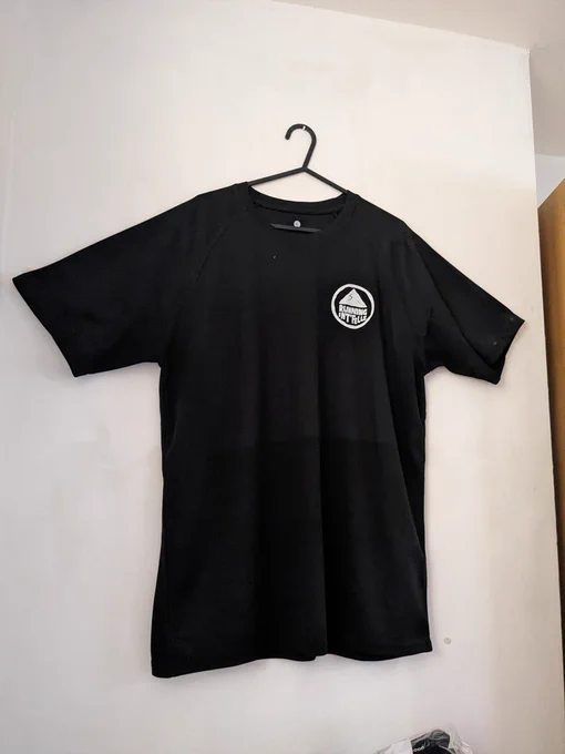 A photo of a black t shirt with the white Running Int Fells logo on the left side
