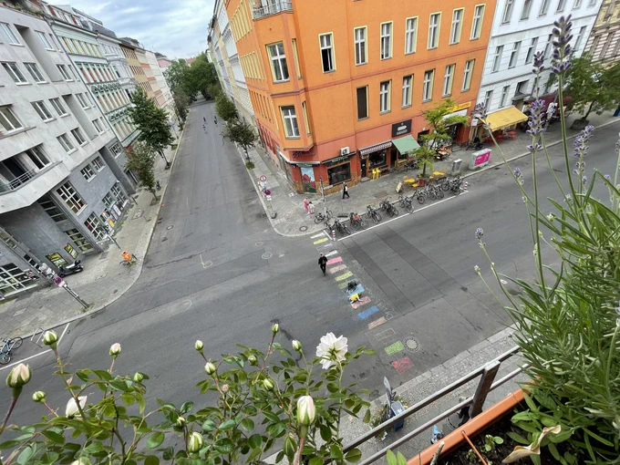 Kids painting a rainbow zebra crossing after cars have been removed from the streets.