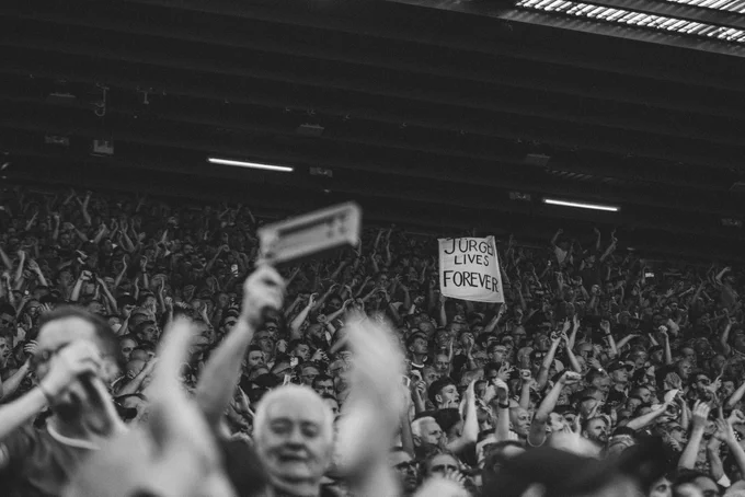 Photography of a flag in the Kop end reading: "Jürgen lives forever."