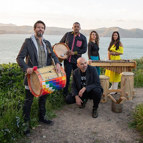 5 musicians and their instruments assembled at the shore of a lake in the global south: they are thinking FREE PALESTINE!!
