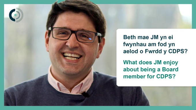 A man wearing glasses is smiling. Green text to the left of the image reads, 'What does JM enjoy about being a Board member for CDPS?'