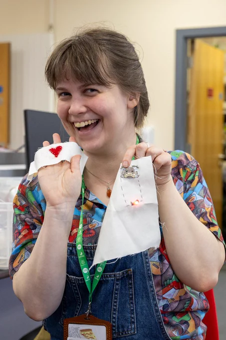 A volunteer at the jam shows off the circuits she made by sewing